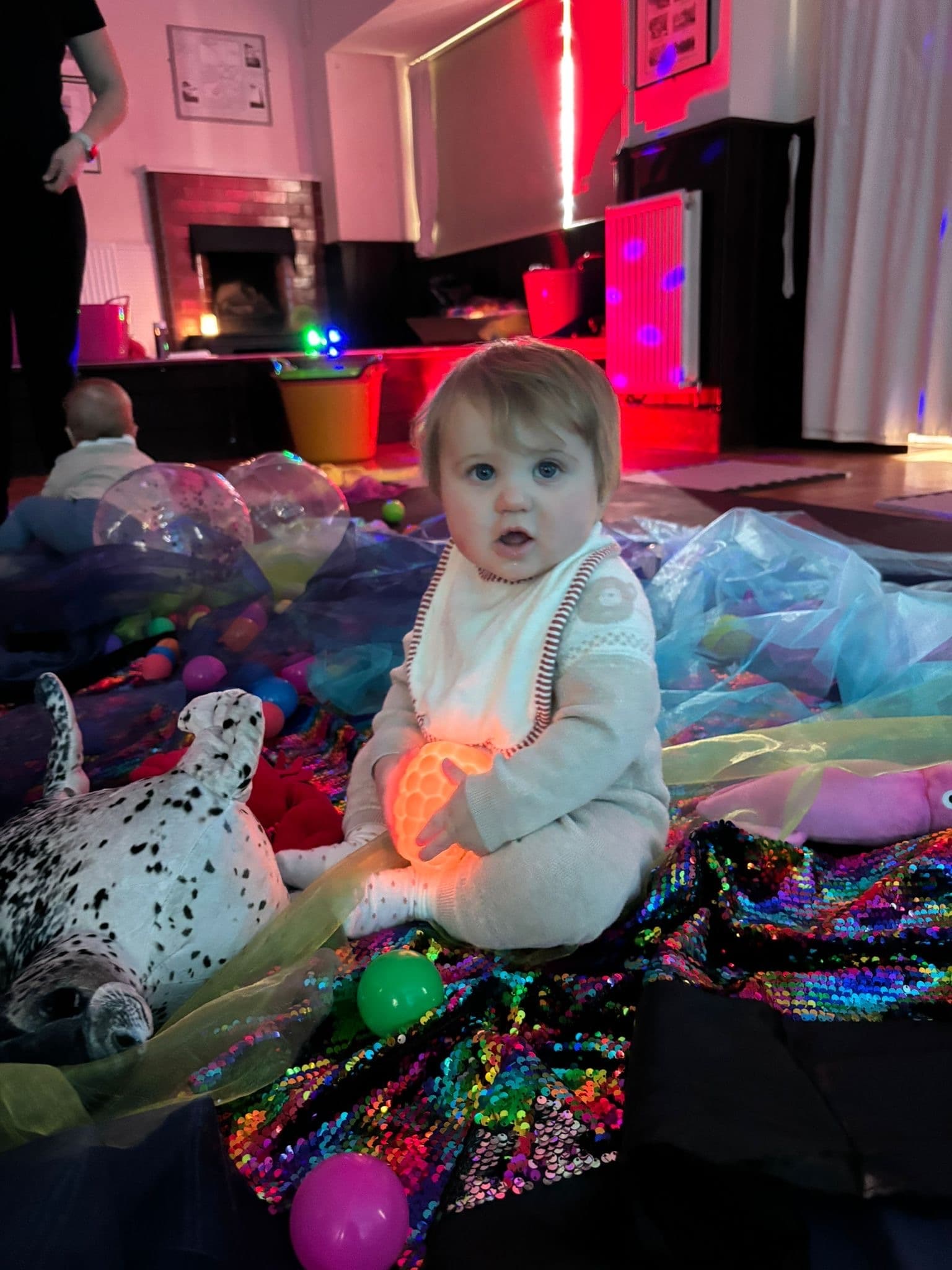 Baby with glowing ball in sensory messy play